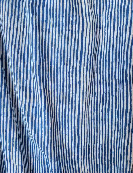 Close up of indigo and white stripe print. Lines are not perfectly straight.
